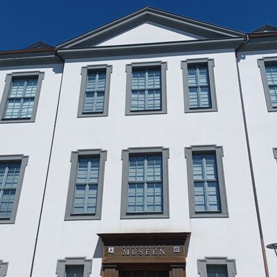 Historische Fassade vom Museum. Das Junkerhaus mit Eingangsportal. Strahlend blauer Himmel im Hintergrund.